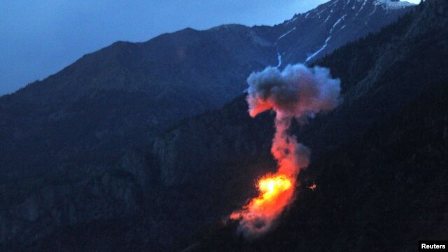 Two bombs explode at dusk on a Taliban fighting position above Kamdesh in Nuristan Province on June 11.