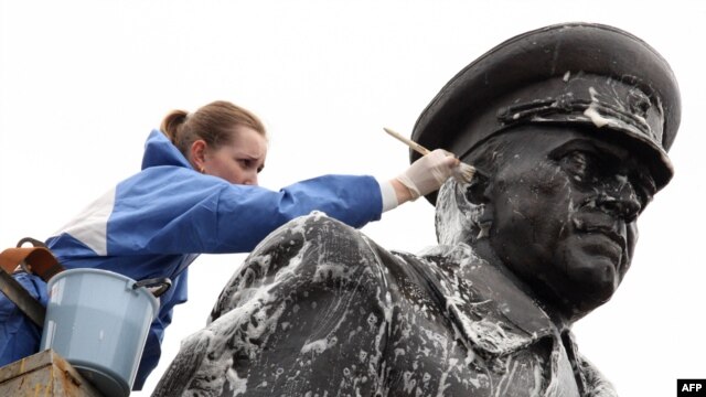 A municipal worker cleans a statue of Soviet World War II hero Marshal Georgy Zhukov in St. Petersburg in preparation for Victory Day festivities.