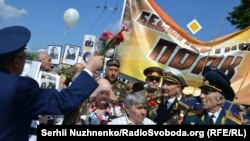 Ветераны войны держат баннер "Бессмертный полк" в Парке Славы. Киев, 9 мая 2016 года.