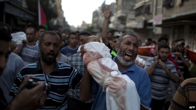 A Palestinian man shouts as he carries the body of 1-year-old baby Noha Mesleh, who died of wounds sustained after a UN school in Beit Hanun was hit by an Israeli tank shell, during her funeral in Beit Lahia in the Gaza Strip on July 25.