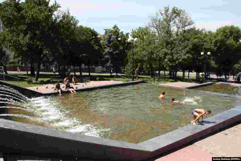 Children play in a public fountain.