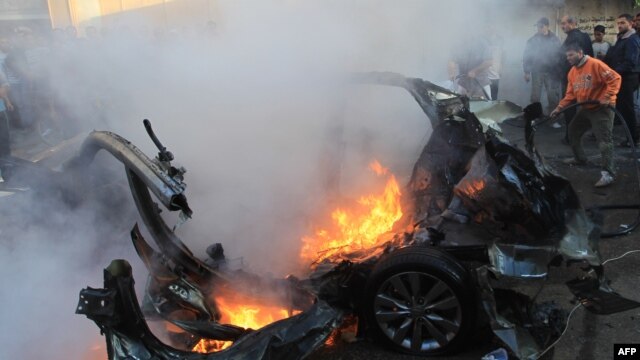 Palestinian firefighters extinguish flames from the car of Ahmed al-Jaabari,  head of the military wing of the Hamas movement, after it was hit in an Israeli air strike in Gaza City on November 14.