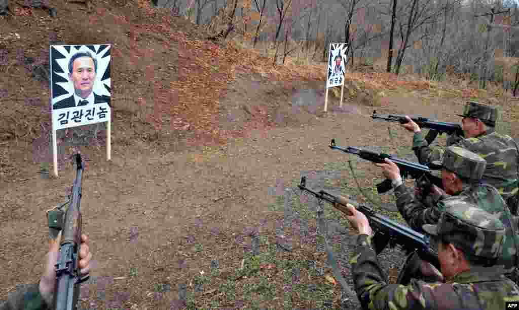 This photo provided by North Korea's official Korean Central News Agency shows North Korean soldiers shooting at targets carrying the images of South Korean Defense Minister Kim Kwan-Jin (left) and a U.S. soldier at an undisclosed location. (AFP)