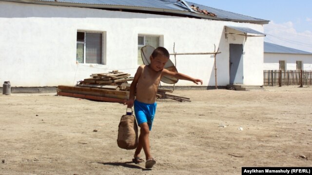 Пластик бөтелкемен су тасып жүрген бала. Қызылорда облысы Қармақшы ауданы Көмекбаев ауылы, 16 шілде 2013 жыл. (Көрнекі сурет)