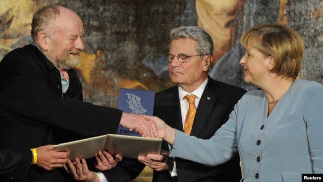 Danish cartoonist Kurt Westergaard (left) is congratulated on his prize by German Chancellor Angela Merkel (right) at the M100 Media Prize ceremony in Potsdam on September 8