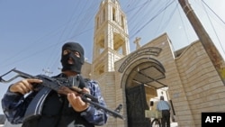 An AFP photo of Iraqi security staff guarding a church in Bartala, which IS supporters have used to claim the militant group is protecting Christian churches in the city of Mosul.