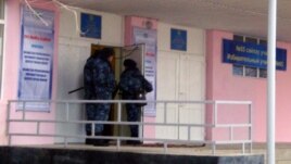 Security forces at a polling station in Zhanaozen in mid-January voting, in the wake of the previous month's deadly clashes