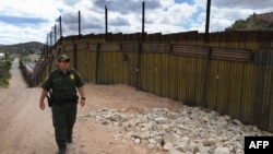 A U.S. security officer patrols along a border fence with neighboring Mexico designed to keep out illegal immigrants.