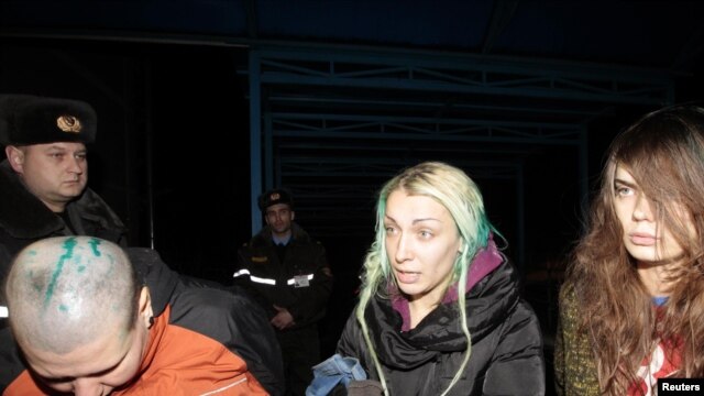 Ukrainian Femen activists Aleksandra Nemchinova, Inna Shevchenko, and Oksana Shachko (left to right) speak to reporters at a hospital in the Belarusian town of Elsk on December 20.