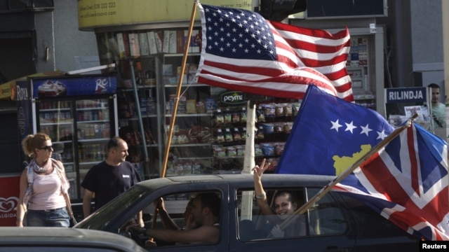 Kosovars wave the U.S., Kosovo, and U.K. flags as they celebrate in Pristina on July 22, 2010, after the World Court said Kosovo's declaration of independence was legal.