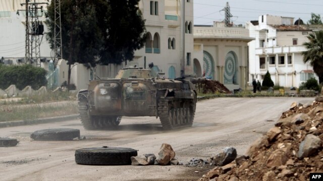 Security forces patrol a street in the district of Al-Waar in the flashpoint city of Homs on May 2.