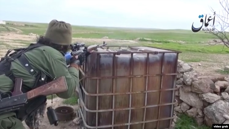 Скриншот размещенного в Сети видео, показывающего русскоговорящих боевиков группировки "Исламское государство" недалеко от города Кобани.