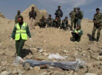 Afghan security officials remove the body of boy who was killed by an unexploded mortar shell on November 6 outside of Kabul (epa)