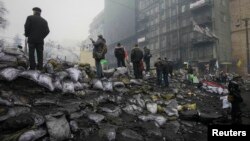People stand on the protest barricades in Kyiv on February 10.
