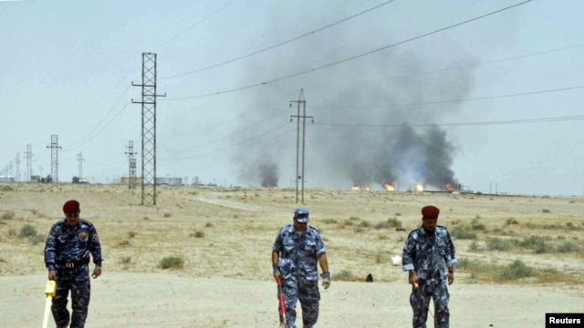 Iraqi police scan for land mines near the Rumaila oil field in Basrah province.