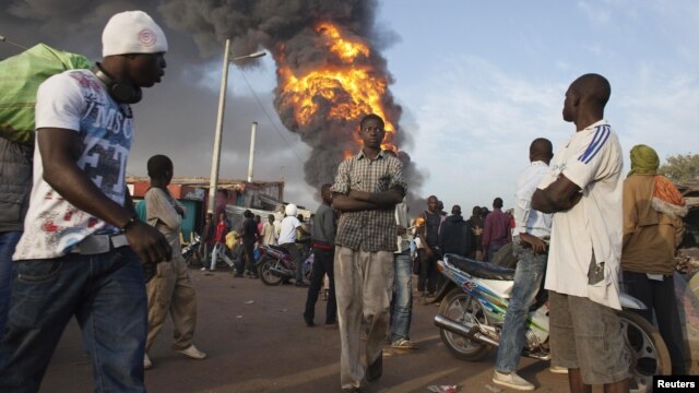 Onlookers walk past a fire at Ngolonina market in the Malian capital of Bamako on January 12.