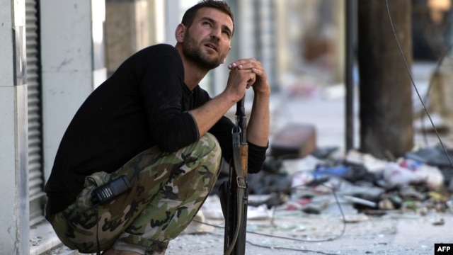A Syrian rebel fighter watches the sky after hearing a helicopter Aleppo's al-Amiriya neighborhood on September 24. 