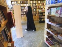 A woman browses at a Tehran bookstore that has so far escaped the crackdown (AFP)