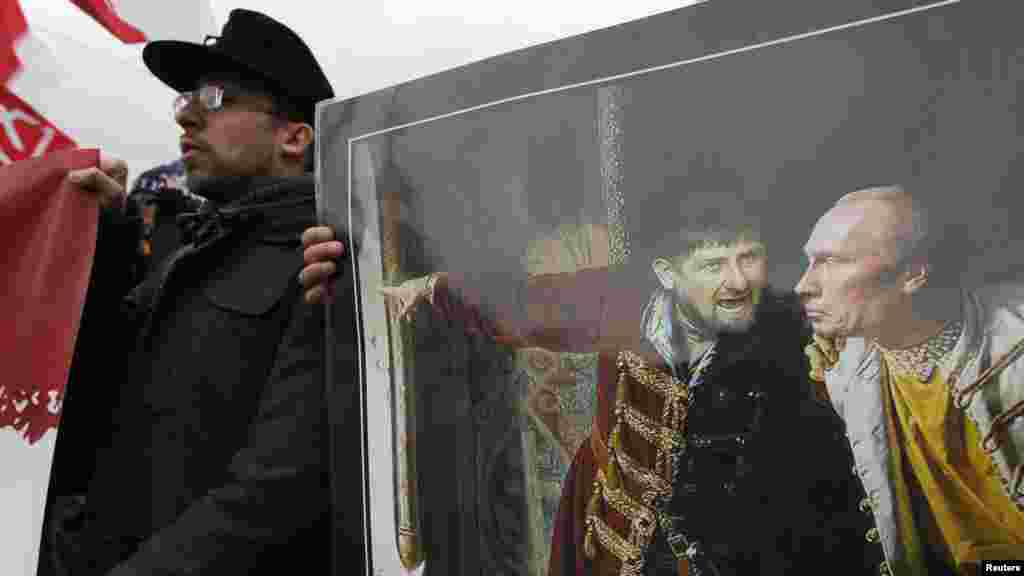 Participants hold a painting depicting Russian President Vladimir Putin (right) and pro-Kremlin Chechen leader Ramzan Kadyrov.