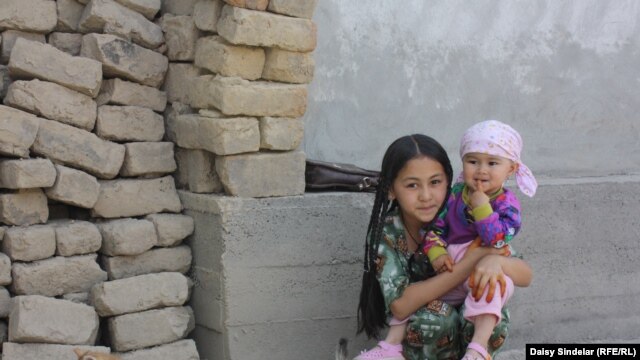Ten-year-old Madina, an ethnic Uzbek, holds her niece in the courtyard of her family home in an Uzbek mahalla in the southern Kyrgyz city of Osh. Her family’s home was destroyed by fire in the June 2010 ethnic clashes.