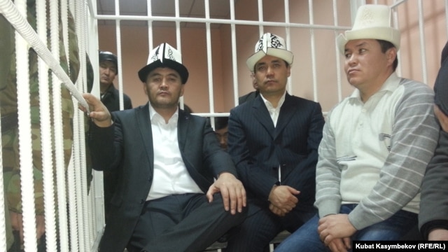 Opposition deputies Kamchybek Tashiev, Sadyr Japarov, and Talant Mamytov (left to right) in the dock at the start of their trial in Bishkek on January 10.