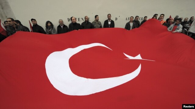 France -- Franco-Turk protesters hold a giant Turkish flag during a demonstration next to the National Assembly in Paris, 22Dec2011