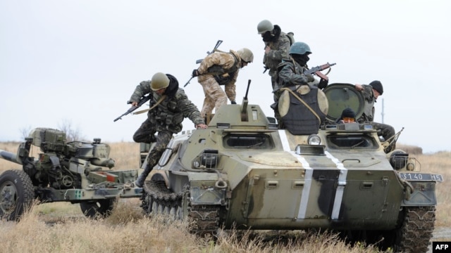 Ukrainian soldiers clamber aboard an armoured vehicle near Mariupol. (file photo)