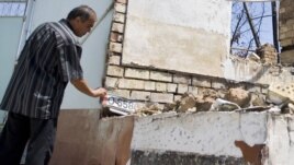 An ethnic Uzbek man in the yard of his house, burned out during the ethnic clashes in Osh in June.