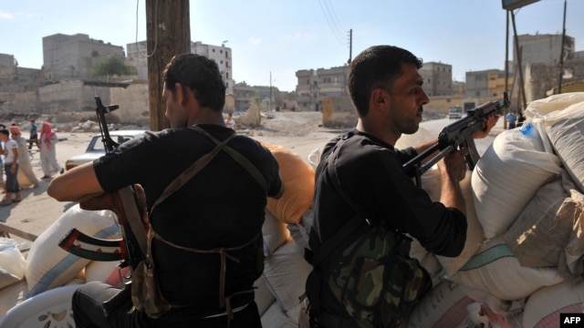 Syrian rebels man a checkpoint in Aleppo.