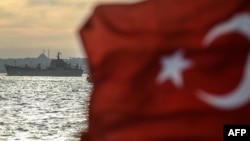 A Turkish flag flies on a ferry as Russian warship, the BSF Saratov 150, sails through the Bosphorus off Istanbul en route from the Black Sea to the eastern Mediterranean late last year.