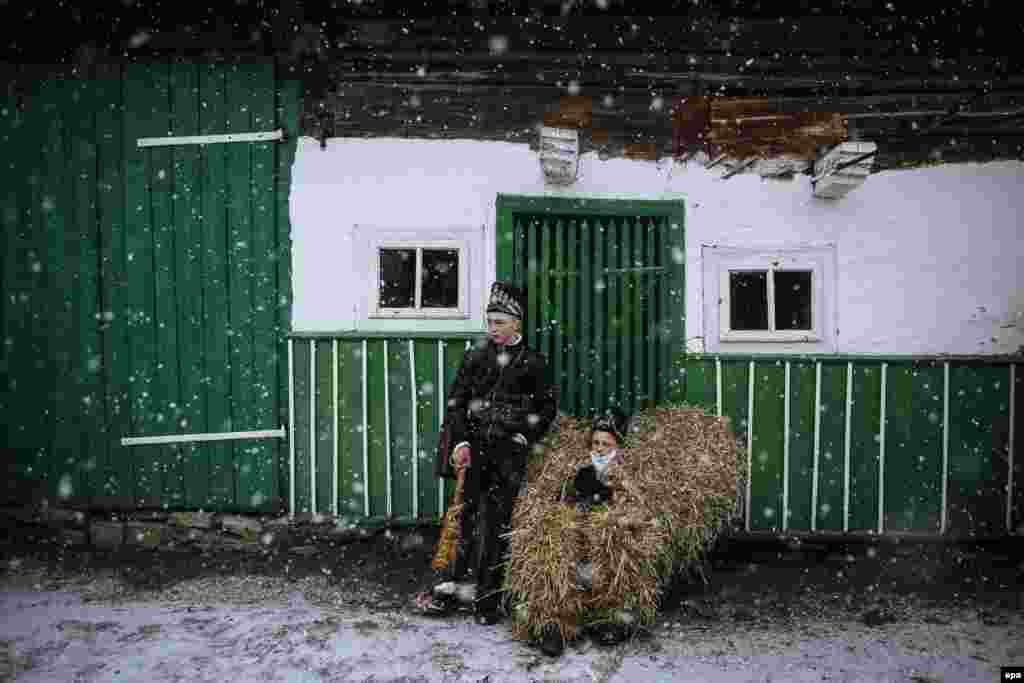 Locals wearing costumes rest as they walk from house to house and perform short plays during celebrations of the winter festival of Malanka in western Ukraine on January 14. (epa/Roman Pilipey)