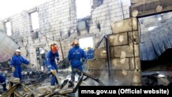 Өртенген қарттар үйі орнында жүрген өртке қарсы күрес қызметкерлері. Украина, 29 мамыр 2016 жыл.