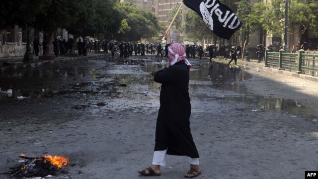 An Egyptian protester holds an Al-Qaeda affiliated flag near the U.S. Embassy in Cairo on September 14.