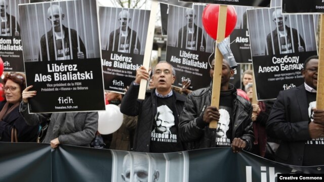 Supporters outside the Belarusian Embassy in Paris in 2011 hold signs of Ales Byalyatski.