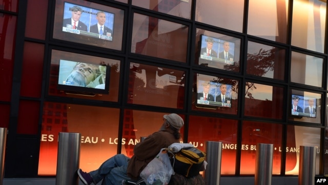 A man watches the first presidential debate between Democratic President Barack Obama and Republican challenger Governor Mitt Romney in front of an office building along Sunset Boulevard in Hollywood, California on October 3.