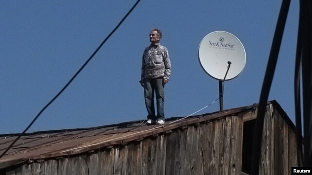 A Georgian man looks on after checking a satellite dish on the roof of a building in Tbilisi in April.
