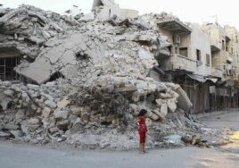 Бомба түсіп қираған үйдің қасында тұрған қыз. Сирия, 8 қыркүйек 2013 жыл.