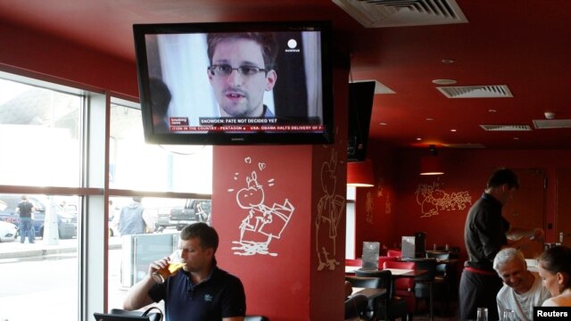 A television shows former U.S. intelligence contractor Edward Snowden during a news bulletin at a cafe at Moscow's Sheremetyevo Airport.