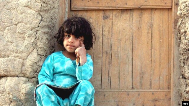 An Afghan girl sits outside her house in Kabul (file photo)