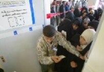 Voters line up at a polling station in Al-Najaf today