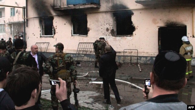 People use their mobile phones to take photos of the scene of a gunfight between Russian security forces and militants in the Chechen capital, Grozny, in April 2011.