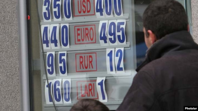 A man and child look at the exchange rate in Yerevan as the Armenian dram lost some 30 percent of its value in one day