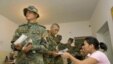 Soldiers receive ballot papers before casting their votes in a referendum at a polling station in Osh 