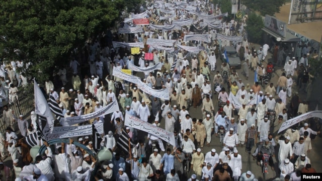 Pakistani protesters hold banners and flags while taking part in an anti-American protest rally in Karachi on September 21.
