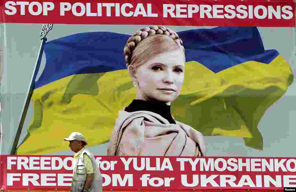 A man walks past a board with a portrait of jailed fomer Ukrainian Prime Minister Yulia Tymoshenko in central Kyiv on June 1. (Reuters/Gleb Garanich) 