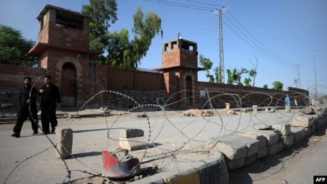 Pedestrians walk past the jail where Pakistani physician Shakil Afridi is being held after he was sentenced to 33 years in prison for helping U.S. forces kill Osama bin Laden.