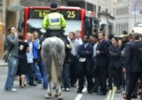 Workers in London's financial district receive directions from police after their buildings were evacuated