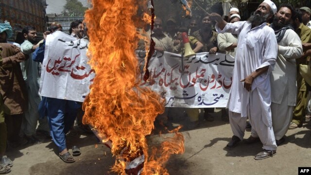 Pakistani protesters burn the U.S. flag during a protest in Multan against drone strikes.
