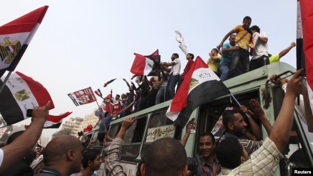 Supporters of the Muslim Brotherhood's presidential candidate, Muhammad Morsi, celebrate on top of a bus at Tahrir Square in Cairo on June 18.
