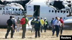 U.S. National Transportation Safety Board investigators work at the scene of the Asiana Airlines Flight 214 crash site at San Francisco International Airport in California on July 7.